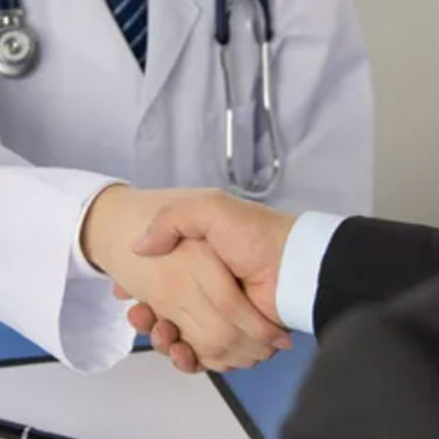 Healthcare executive and physician shaking hands as part of a high value network agreement