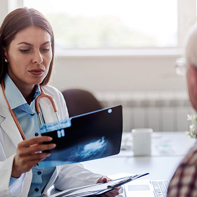 Specialist physician looking at an xray while meeting with a patient.