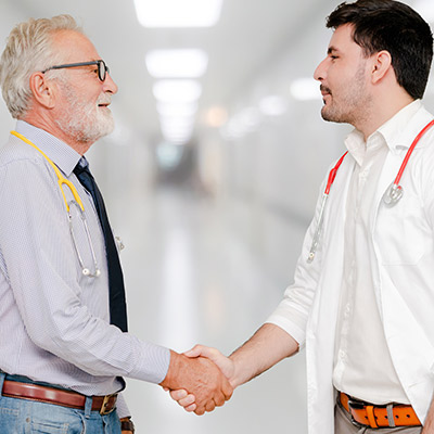 Two doctors shaking hands in agreement to co manage patients in a high value network
