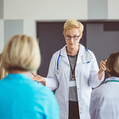 Female doctor teaching a class about the importance of referral coordination within a high value network